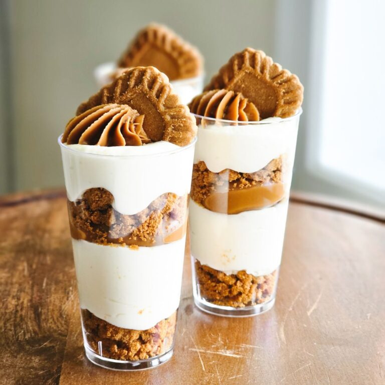 Biscoff no-bake cheesecake dessert shooters topped with creamy biscoff and a Biscoff cookie slice