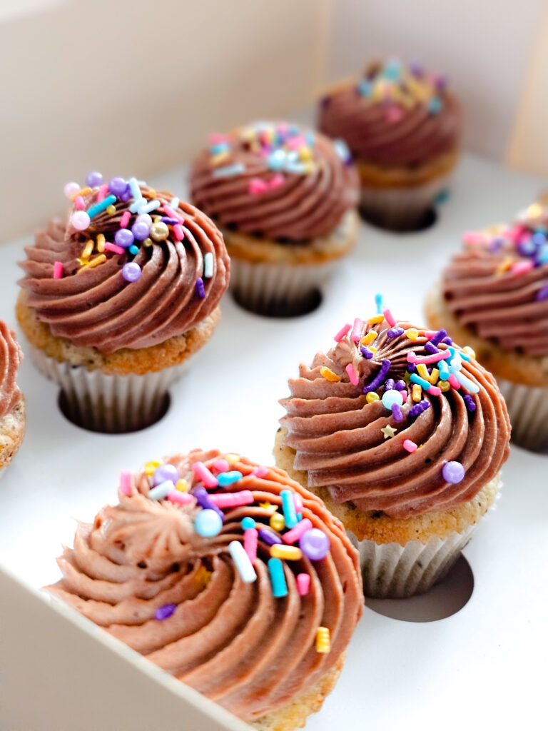 Petite cookies and cream cupcakes topped with chocolate buttercream frosting and decorative sprinkles