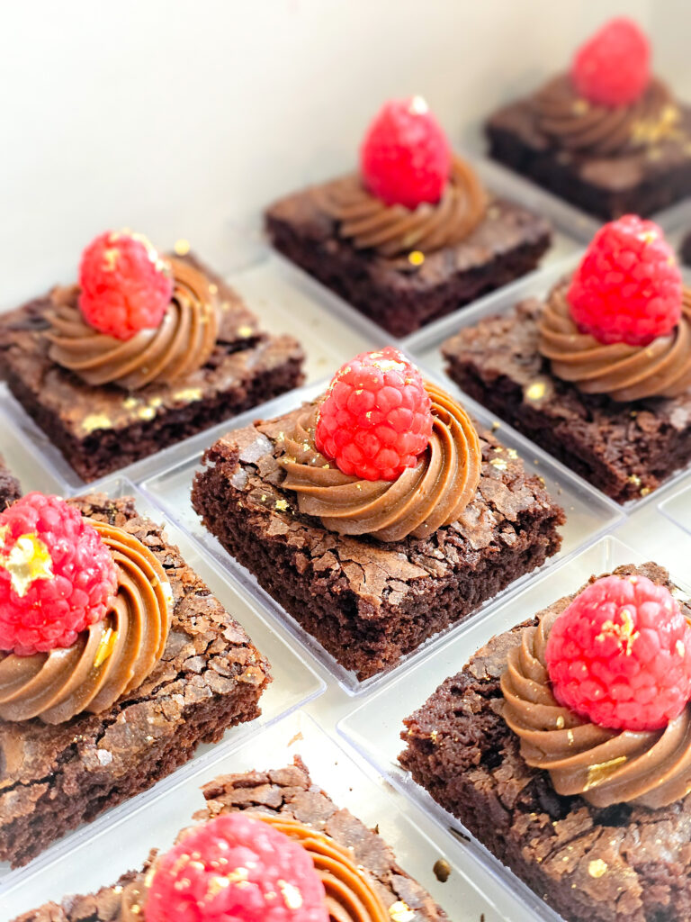 Petite brownie squares topped with chocolate mousse and a raspberry